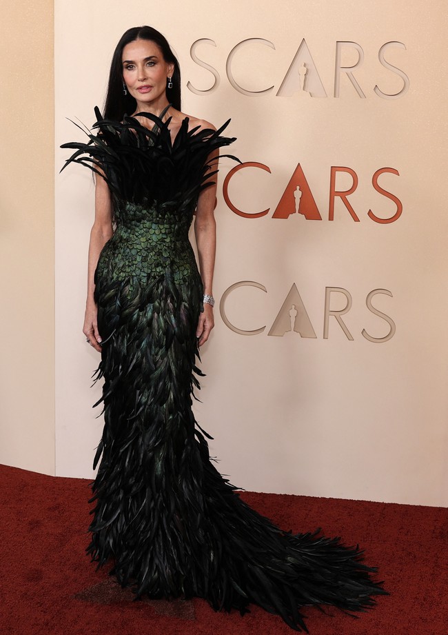 Demi Moore tampil dramatis di karpet merah dengan gaun Gucci khusus yang dihiasi detail bulu. Siluetnya yang glamor membuat penampilan aktris ini langsung mencuri perhatian. Foto: REUTERS/DANIEL COLE