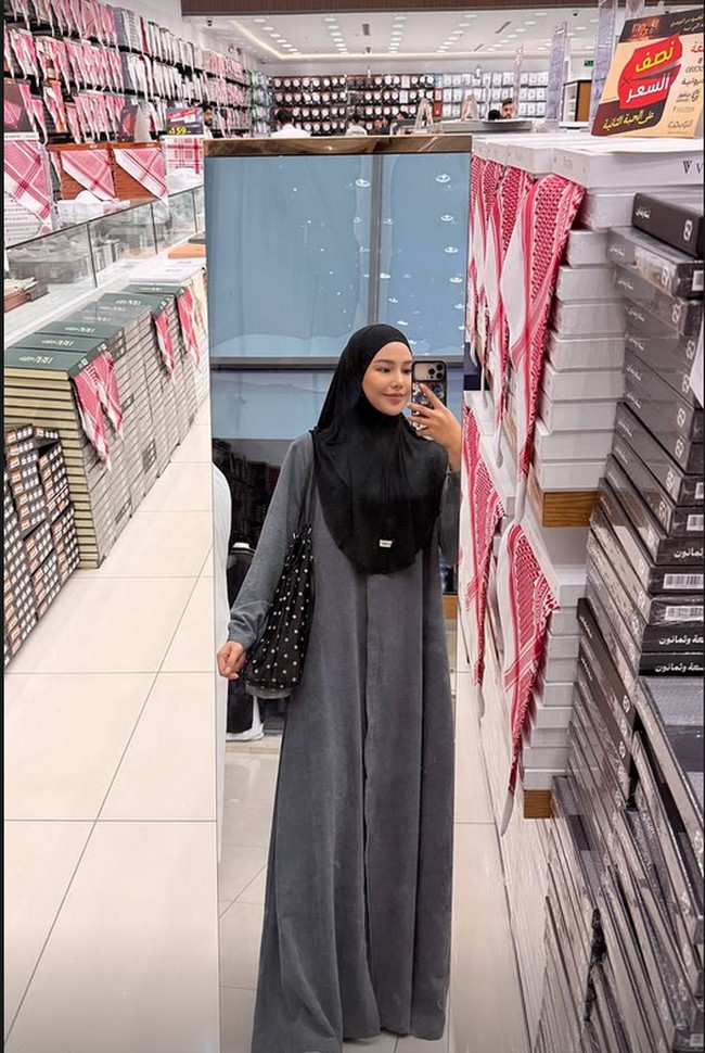 Dara Arafah tampil dalam balutan gamis abu-abu dan hijab hitam yang simpel saat melakukan mirror selfie di sebuah pertokoan di Tanah Suci menjelang malam terakhir Ramadan 2026. Di tengah agenda ibadah umrah bersama suami, Rehan Mubarak, selebgram ini tampak menikmati momen santai berbelanja kebutuhan ibadah dengan suasana toko yang rapi dan dipenuhi jajaran kain khas Timur Tengah. Foto: Dok. Instagram @daraarafah.