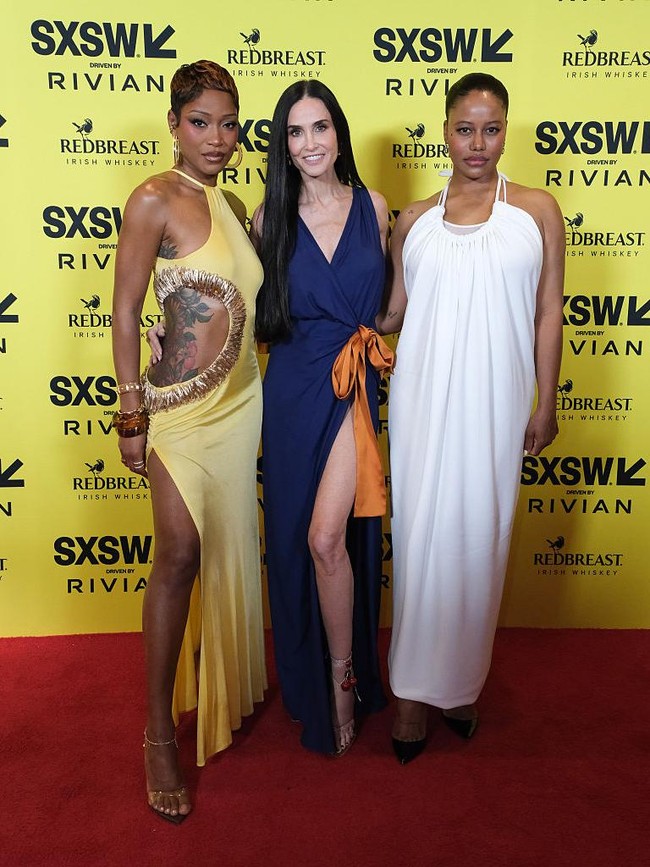 Aksen pita oranye berukuran besar di bagian pinggul menjadi elemen paling mencolok dari keseluruhan tampilan. Foto: SXSW Conference & Festivals via /Adam Kissick