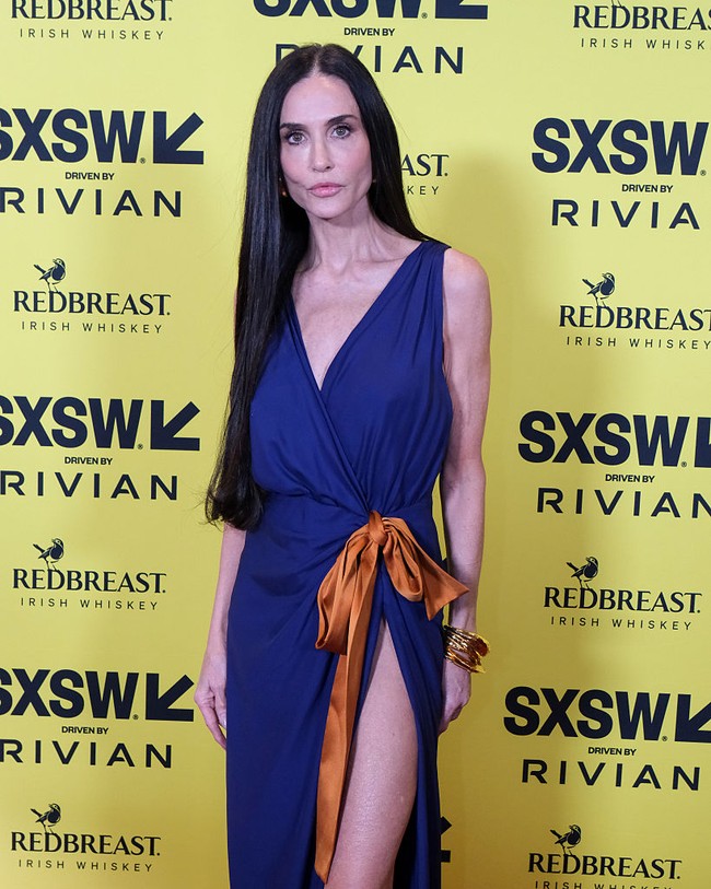 Gaun dirancang dengan garis leher menjuntai serta belahan paha tinggi, memperlihatkan kaki jenjang Demi Moore. Foto: SXSW Conference & Festivals via /Adam Kissick
