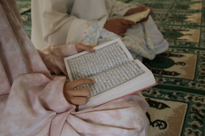 Perempuan muslim membaca Al-Quran.