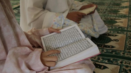Perempuan muslim membaca Al-Quran.