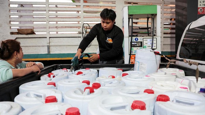 A worker fills plastic jerrycans with fuel at a fuel station, before Thailand's diesel price freeze expires on Monday, amid concerns about rising fuel prices linked to the U.S.-Israel conflict with Iran, in Nakhon Pathom province on the outskirts of Bangkok, Thailand, March 16, 2026. REUTERS/Chalinee Thirasupa REFILE - CORRECTING INFORMATION FROM 