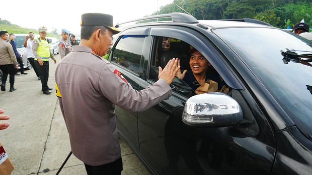 Kapolri Jenderal Listyo Sigit Prabowo meninjau kesiapan arus mudik Lebaran 2026 di GT Kalikangkung, Semarang. Dia membagikan bingkisan kepada para pemudik. (dok Polri)