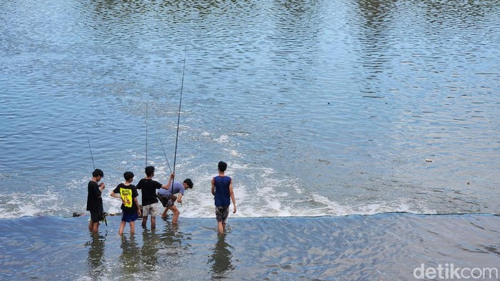 Suasana sore di Tandon Lengkong Wetan dimanfaatkan warga untuk menghabiskan waktu menjelang berbuka puasa atau ngabuburit, Senin (16/3/2026). Sejumlah warga terlihat melakukan berbagai aktivitas santai seperti memancing, jogging, hingga sekadar duduk menikmati suasana di sekitar area tandon.
