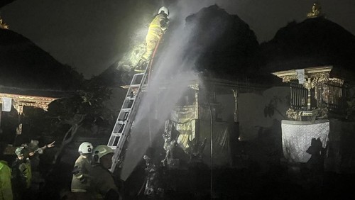 Petugas Damkar berjibaku memadamkan atap pura yang terbakar tersambar petir di Lingkungan Banjar Celuk, Kelurahan Kapal, Mengwi, Badung, Minggu (15/3/2026). (Foto: Dok. Polres Badung)