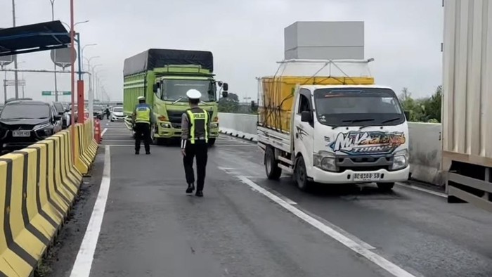 Polisi melakukan pengaturan lalu lintas di pintu tol