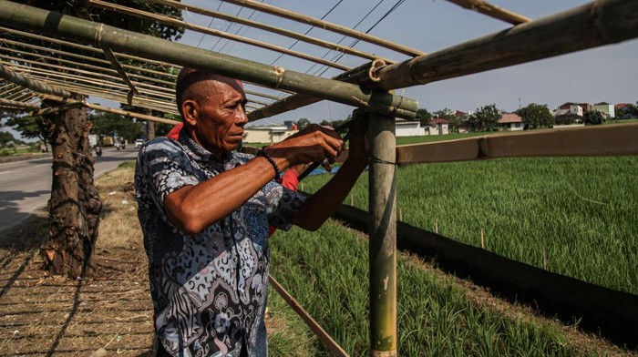 Warga membuat bangunan warung semi permanen di Jalan Raya Pantura, Tanjungpura, Karawang, Senin (16/3/2026). Bangunan yang akan dijadikan warung musiman tersebut mulai buka saat arus mudik Lebaran untuk menjual makan dan minum untuk para pemudik beristirahat. ANTARA FOTO/Darryl Ramadhan