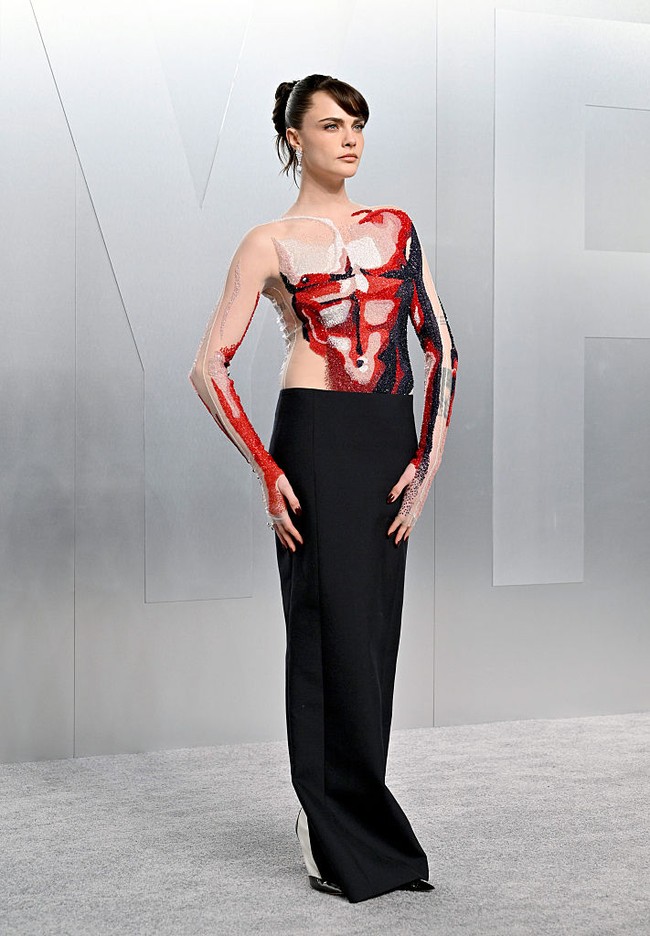 Definisi ‘nude dress’  yang berbeda diberikan oleh Cara Delevingne lewat gaun Thom Browne yang membungkus tubuhnya.  Dengan teknik trompe-lœil yang memberi efek ilusi pada mata, tampil seksi tak melulu harus busana yang terbuka sepenuhnya. (Foto: Axelle/Bauer-Griffin/FilmMagic)