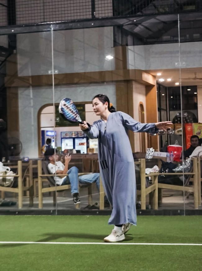 Hesti mengenakan gamis panjang berwarna abu-abu kebiruan. Gamis tersebut dipadukan dengan sepatu sneakers putih. Rambutnya tampak sederhana dengan hanya diikat satu ke belakang. Foto: Instagram/@hestipurwadinata