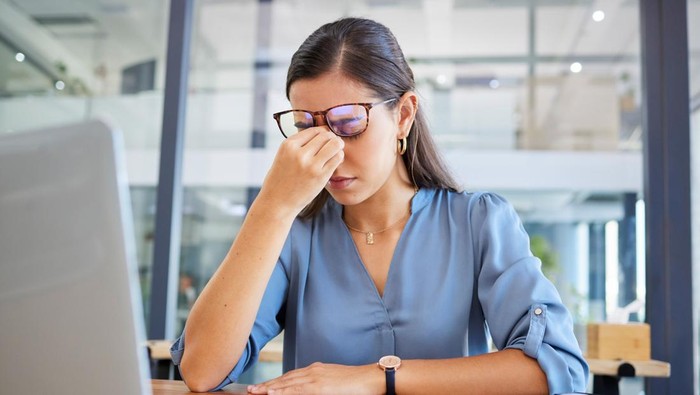 Stress headache, burnout and woman in office overwhelmed with workload at desk with laptop. Frustrated, overworked and tired woman with computer at startup, anxiety from deadline time pressure crisis