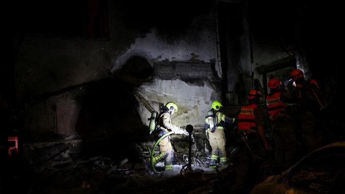 Firefighters work at the scene of a Hezbollah rocket attack on a residential building, amid escalation between Hezbollah and Israel, and amid the U.S.-Israeli conflict with Iran, in Nahariya, northern Israel, March 16, 2026. REUTERS/Shir Torem     TPX IMAGES OF THE DAY