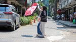 Jakarta Memanas, Warga Berlindung dari Terik dengan Payung
