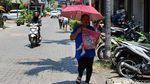 Jakarta Memanas, Warga Berlindung dari Terik dengan Payung