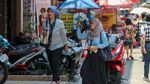 Jakarta Memanas, Warga Berlindung dari Terik dengan Payung