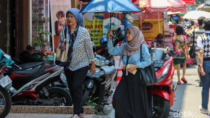 Warga berjalan menggunakan payung di kawasan Pasar Baru, Jakarta Pusat, Selasa (17/3/2026). Payung digunakan untuk melindungi diri dari terik matahari saat beraktivitas di luar ruangan di tengah cuaca panas.