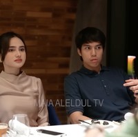 Syifa Hadju tampil cantik kenakan atasan lengan panjang satin warna coklat. Penampilannya terlihat simpel dengan tatanan rambut rapi terikat ke belakang. Sementara El memilih polo shirt warna navy. Foto: YouTube/MAIA ALELDUL TV