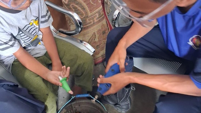 Petugas damkar saat mengevakuasi jari bocah tersangkut di cetakan kue
