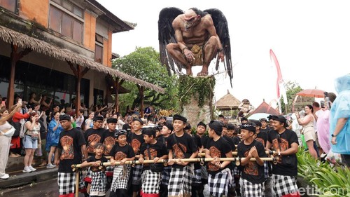 Antusiasme para turis asing menunggu penampilan ogoh-ogoh saat diguyur hujan di catus pata Ubud Jalan Suweta, Ubud, Gianyar, Rabu (18/3/2026). (Aryo Mahendro/detikBali)