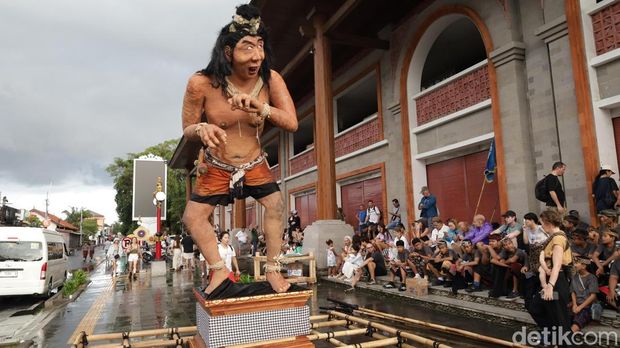 Antusiasme para turis asing menunggu penampilan ogoh-ogoh saat diguyur hujan di catus pata Ubud Jalan Suweta, Ubud, Gianyar, Rabu (18/3/2026). (Aryo Mahendro/detikBali)