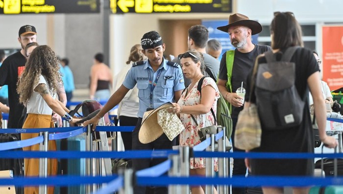 Penumpang pesawat antre di tempat lapor diri Terminal Keberangkatan Internasional Bandara Internasional I Gusti Ngurah Rai, Badung, Bali, Rabu (18/3/2026). Bandara Bali akan berhenti beroperasi sementara selama 24 jam saat Hari Raya Nyepi tahun Saka 