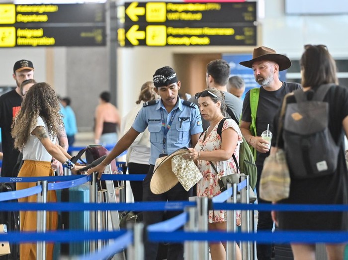 Penumpang pesawat antre di tempat lapor diri Terminal Keberangkatan Internasional Bandara Internasional I Gusti Ngurah Rai, Badung, Bali, Rabu (18/3/2026). Bandara Bali akan berhenti beroperasi sementara selama 24 jam saat Hari Raya Nyepi tahun Saka 
