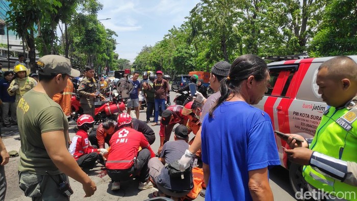 Petugas dibantu warga sedang memadamkan api dan mengevakuasi korban laka lantas di Jalan Rajawali Surabaya