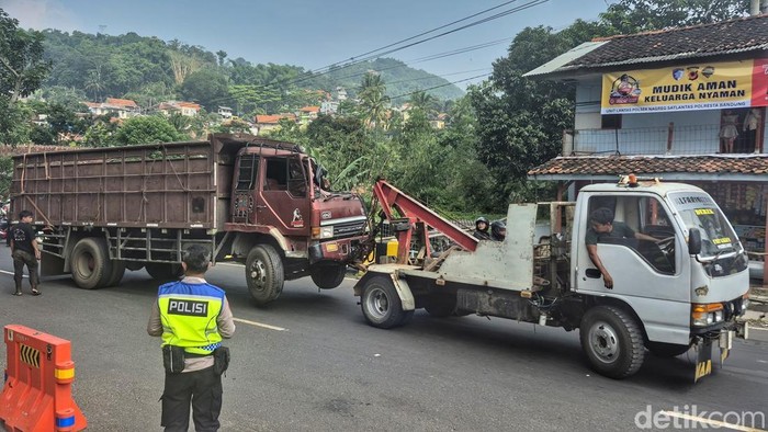 Petugas saat melakukan evakuasi truk muatan sapi di Jalan Raya Nagreg, Cikaledong, Kabupaten Bandung