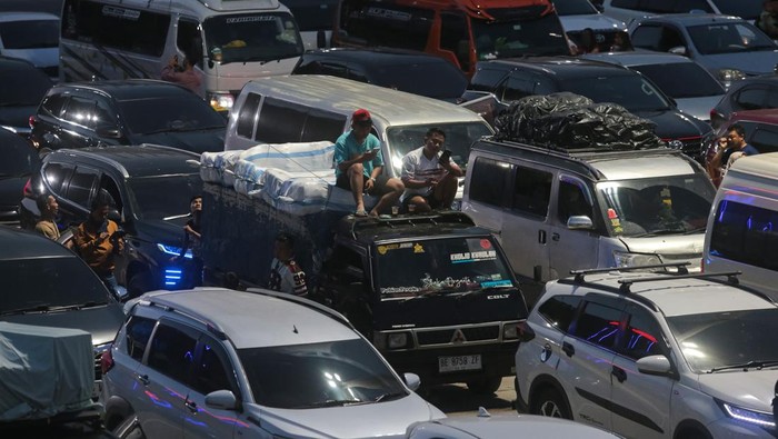 Pemudik duduk di atas kendaraannya saat antre memasuki kapal di Pelabuhan Merak, Kota Cilegon, Banten, Rabu (18/3/2026). PT ASDP Indonesia Ferry (Persero) memperkuat kesiapan layanan penyeberangan Jawa-Sumatera untuk menghadapi lonjakan pada puncak a