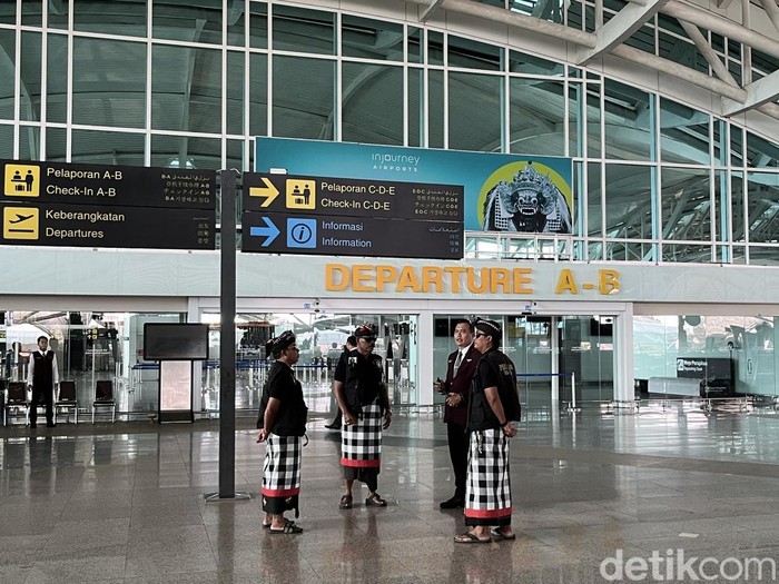 Pecalang berkoordinasi dengan petugas Bandara I Gusti Ngurah Rai, memastikan tidak ada wisatawan yang tercecer.