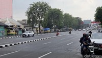 Kendaraan melintas tanpa hambatan di kawasan Wonokromo, Surabaya. Jalan protokol yang biasanya padat kini tampak sepi pada H-2 Idulfitri.