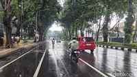 Pengendara melintas di Jalan Darmo, Surabaya, dengan kondisi jalan basah usai hujan. Cuaca sejuk menambah suasana kota yang lebih adem jelang Lebaran.