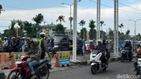Petugas kepolisian melakukan pengaturan lalu lintas dengan memasukkan kendaraan roda dua ke jalur roda empat sebagai upaya mengurai kemacetan.