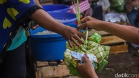 Para pedagang tampak sibuk melayani pembeli yang datang silih berganti. Tangan-tangan terampil mereka dengan cekatan merapikan anyaman kulit ketupat yang siap dijual.