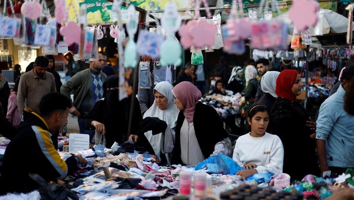 Palestinians shop at a market ahead of Eid al-Fitr in Nuseirat in the central Gaza Strip, March 16, 2026. REUTERS/Mahmoud Issa