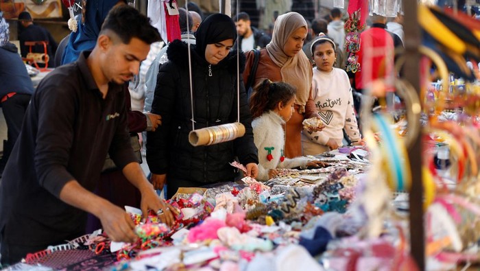 Palestinians shop at a market ahead of Eid al-Fitr in Nuseirat in the central Gaza Strip, March 16, 2026. REUTERS/Mahmoud Issa