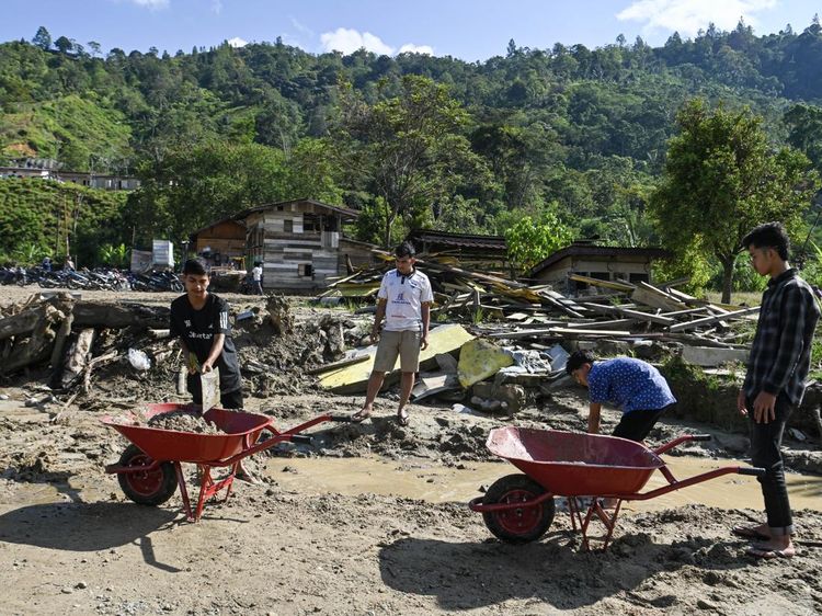 Gotong Royong Warga Bersihkan Sisa Banjir untuk Salat Id