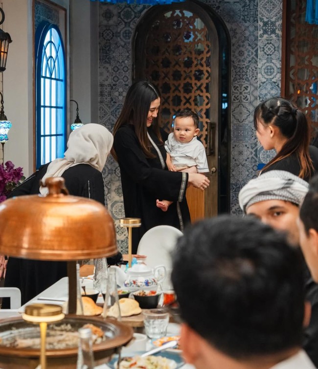 Aaliyah mengenakan outfit hitam panjang yang menyerupai abaya modern. Penampilannya tampak simpel dan sederhana dengan rambut yang dibiarkan terurai. Foto: Instagram/@thariqhalilintar