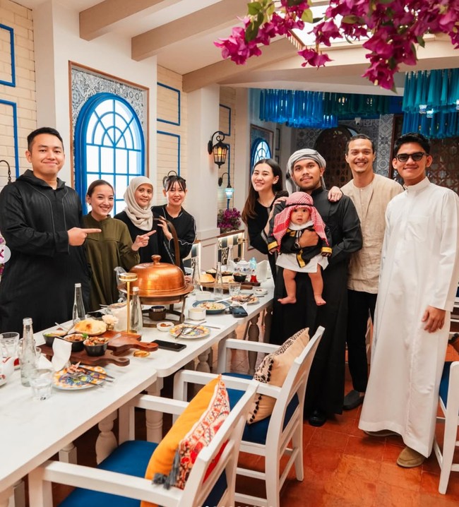 Yang tak kalah curi atensi ialah penampilan sang anak, baby Arash. Sang buah hati tampil menggemaskan dengan busana hitam beraksen emas di bagian lengan. Dipadukan dengan penutup kepala motif merah putih khas Timur Tengah. Foto: Instagram/@thariqhalilintar