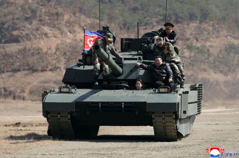 Foto ini diambil pada 19 Maret 2026 dan dirilis oleh Kantor Berita Pusat Korea (KCNA) resmi Korea Utara melalui KNS pada 20 Maret 2026, menunjukkan pemimpin Korea Utara Kim Jong Un dan putrinya Kim Ju Ae menaiki tank selama kunjungan mereka ke Pangkalan Pelatihan Pyongyang No. 60 di bawah Korps Pertahanan Kota Ibu Kota Angkatan Darat Korea Utara.