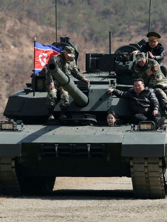 Gadis 14 tahun itu juga mulai rutin mendampingi Kim Jong-un saat menghadiri peluncuran rudal, mengunjungi pangkalan militer, mengamati latihan pasukan, hingga menaiki tank. Dalam beberapa kesempatan, Kim Jong-un terlihat menjelaskan langsung berbagai perlengkapan militer kepada putrinya. Foto: AFP/STR