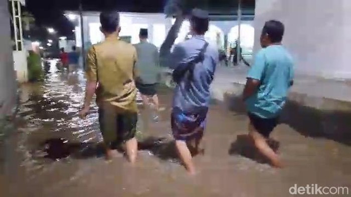 Warga Pasuruan melaksanakan takbiran Idul Fitri dalam kondisi banjir.