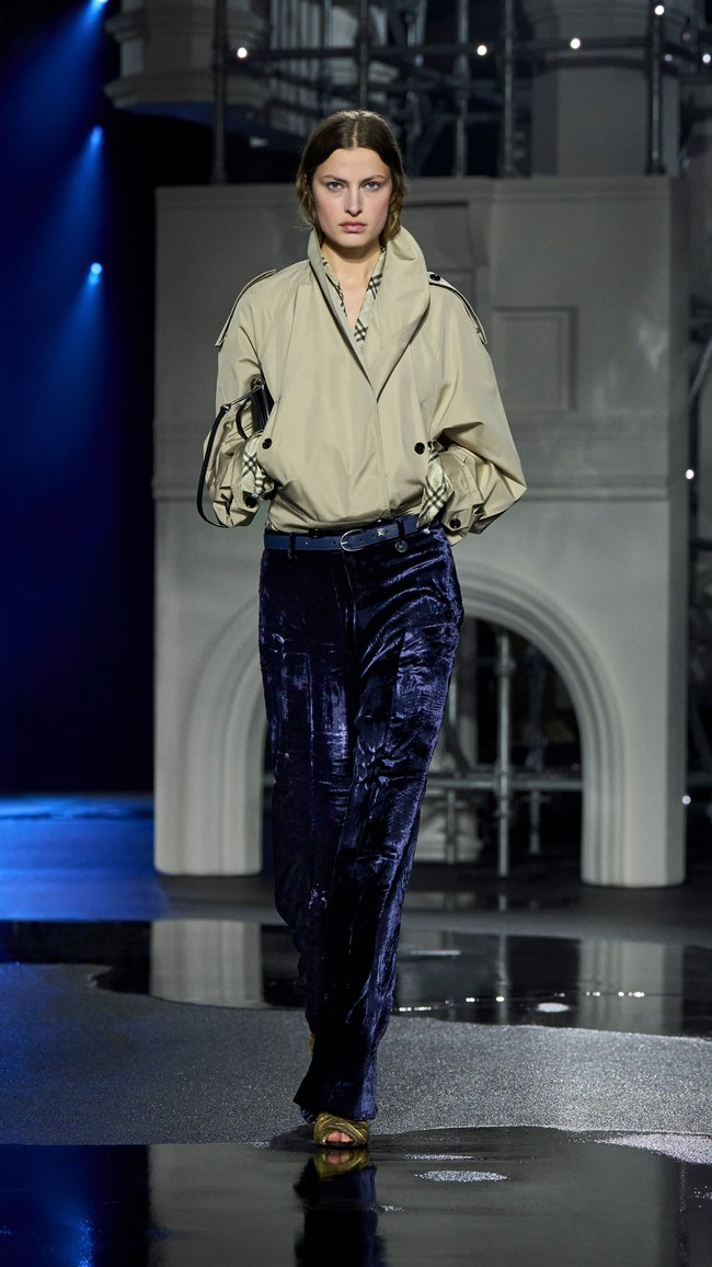 Untuk womenswear, trench coat sebagai icon item Burberry ditampilkan lebih fleksibel. Outerwear ini dikenakan layaknya aksesori di atas gaun satin yang sleek, menciptakan siluet effortless khas perempuan London. (Foto: Dok. Burberry)
