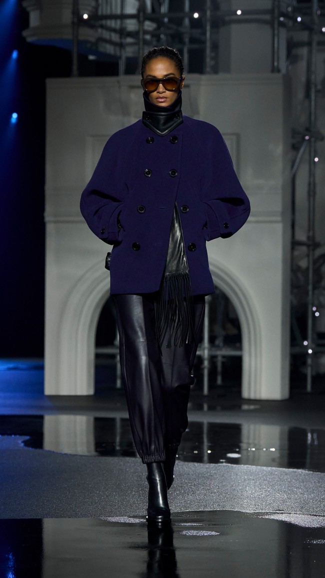 Peragaan busana digelar di Old Billingsgate, London, dengan set yang menampilkan replika Tower Bridge dan suasana jalanan basah khas kota tersebut. Pencahayaan menyerupai lampu jalan menambah dramatisasi koleksi yang ditampilkan. (Foto: Dok. Burberry)