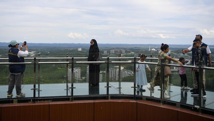 Sejumlah pengunjung berfoto saat berjalan di atas jembatan kaca di glamping Kawasan Inti Pusat Pemerintahan (KIPP) Ibu Kota Nusantara (IKN), Penajam Paser Utara, Kalimantan Timur, Sabtu (21/3/2026). Menurut petugas, jembatan kaca yang dibuka untuk umum saat libur Lebaran 2026 guna menikmati pemandangan kawasan IKN dari ketinggian itu telah dikunjungi sekitar 2.773 orang pengunjung. ANTARA FOTO/M Risyal Hidayat/rwa.
