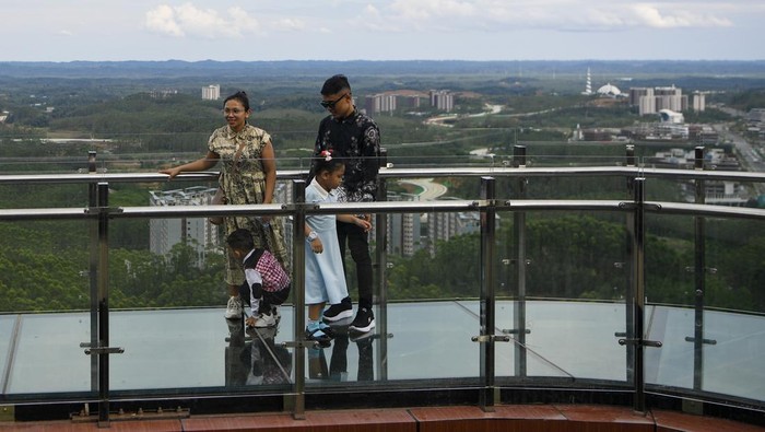 Sejumlah pengunjung berfoto saat berjalan di atas jembatan kaca di glamping Kawasan Inti Pusat Pemerintahan (KIPP) Ibu Kota Nusantara (IKN), Penajam Paser Utara, Kalimantan Timur, Sabtu (21/3/2026). Menurut petugas, jembatan kaca yang dibuka untuk umum saat libur Lebaran 2026 guna menikmati pemandangan kawasan IKN dari ketinggian itu telah dikunjungi sekitar 2.773 orang pengunjung. ANTARA FOTO/M Risyal Hidayat/rwa.
