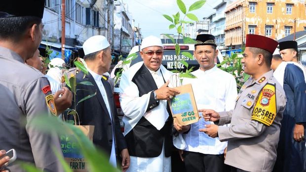 Kapolres Inhu AKBP Farouk Oktora membagikan bibit pohon kepada masyarakat.