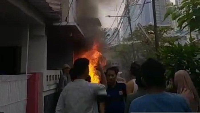 Petugas dan warga mencoba memadamkan api yang membakar sebuah rumah di Kelurahan Bendungan Hilir, Jakarta Pusat, Sabtu (21/3/2026).