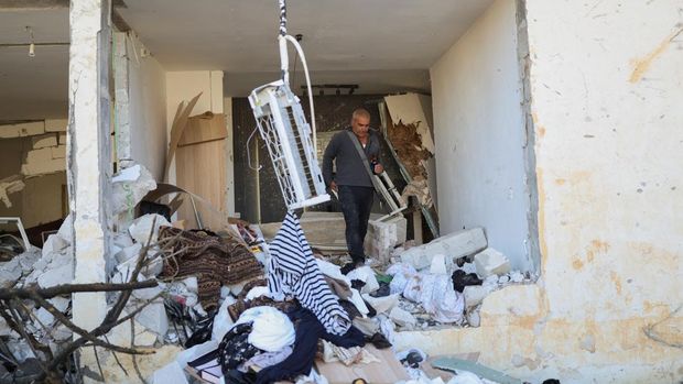 Azran David berjalan di dalam rumahnya yang rusak setelah malam serangan rudal Iran yang melukai puluhan warga Israel, di tengah konflik AS-Israel dengan Iran, di Dimona, Israel selatan, 22 Maret 2026. (REUTERS/Ronen Zvulun)