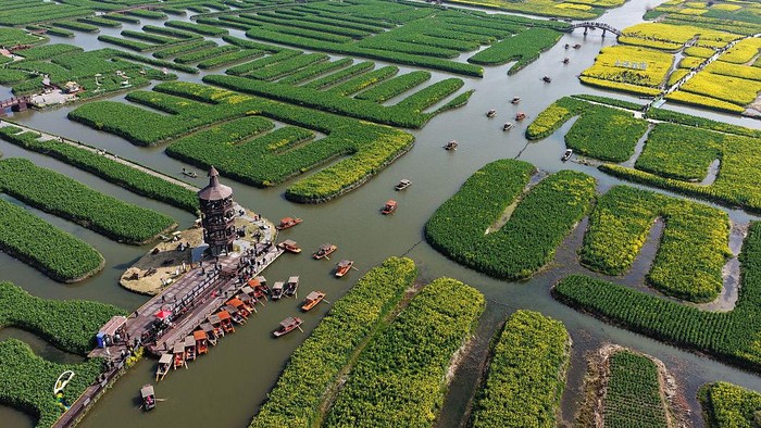 XINGHUA, CHINA - MARCH 21: Aerial view of tourists enjoying rapeseed flowers by boat at the Qianduo scenic area in spring on March 21, 2026 in Xinghua, Jiangsu Province of China. (Photo by Meng Delong/VCG via Getty Images)